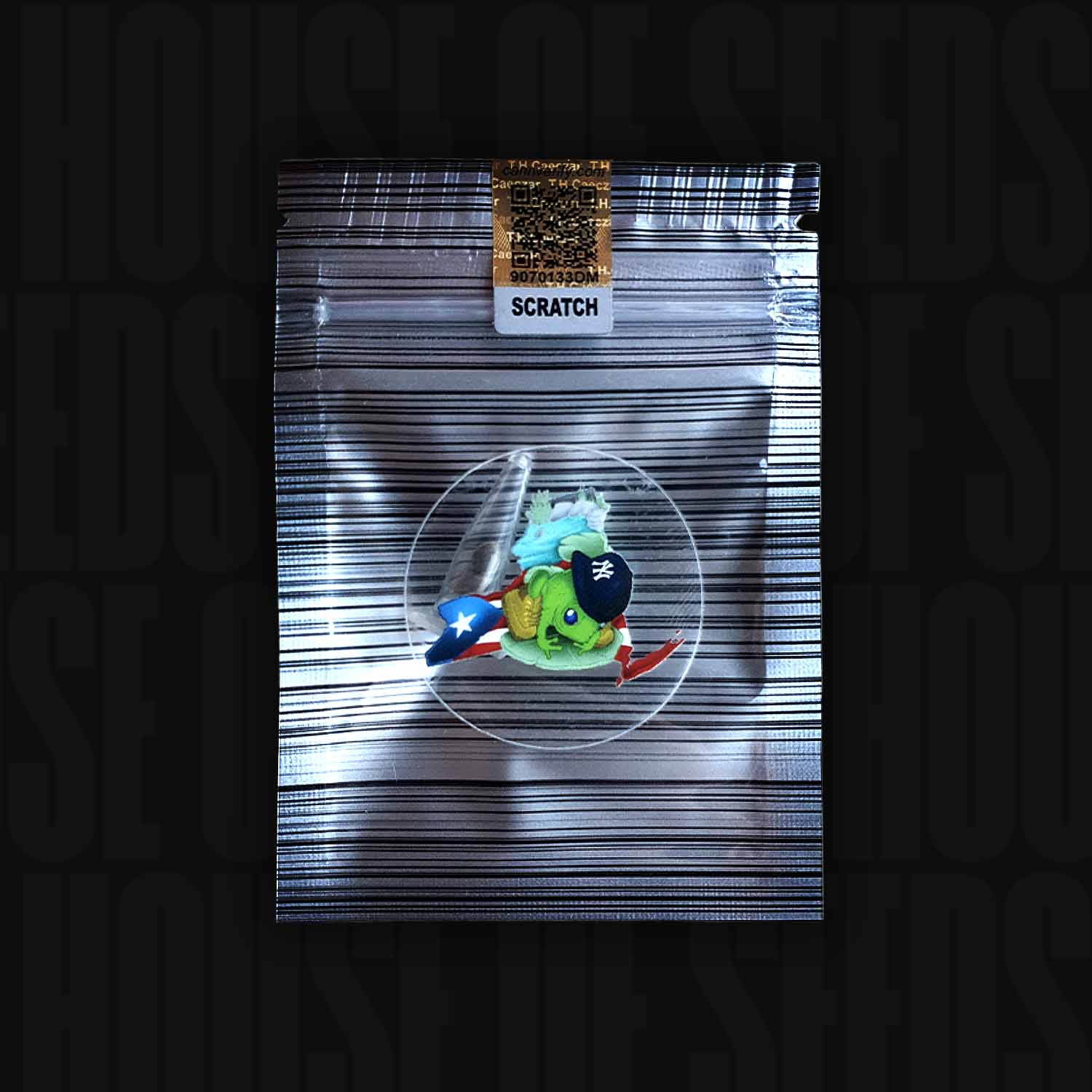 Zu-Tang Clan von N.Y.Ceeds: Kleine grüne Figur mit schwarzer Mütze und puerto-ricanischer Flagge in einem versiegelten silbernen Etui.